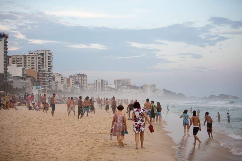 Crowds on Ipanema beach on a hazy afternoon, apartment blocks behind, Rio de Janeiro